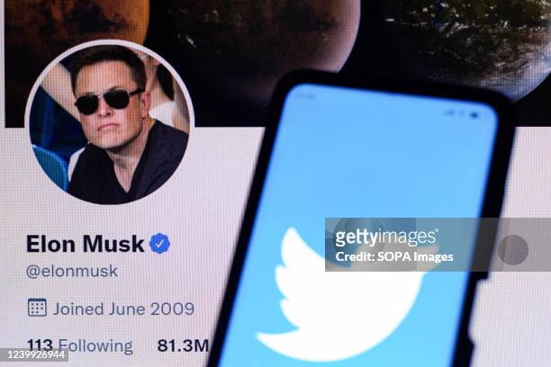In this photo illustration, the Twitter logo is displayed on a smartphone with Elon Musk's official Twitter profile. The billionaire Elon Musk bought...