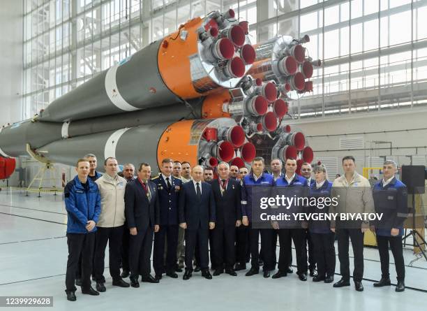 Russian President Vladimir Putin and Roscosmos employees pose for a picture, as he visits the Vostochny cosmodrome, some 180 km north of...