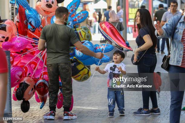Boy looks at a balloon in the center of Baku on June 1, 2020 in Baku, Azerbaijan. Shopping malls and centers, stores and restaurants with outdoor...