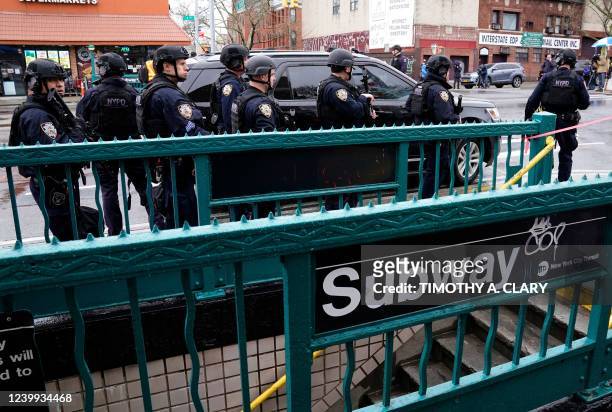 Members of the New York Police Department patrol the streets after at least 13 people were injured during a rush-hour shooting at a subway station in...