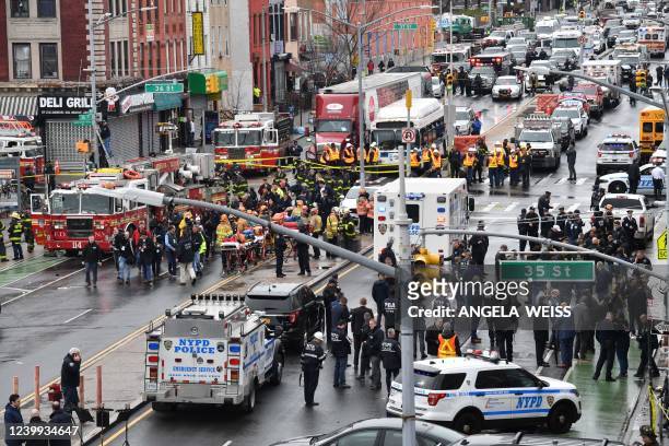 Members of the New York Police Department and emergency vehicles crowd the streets after at least 13 people were injured during a rush-hour shooting...
