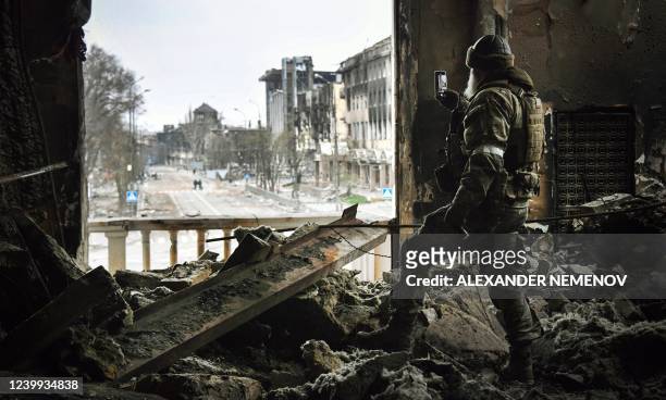 Russian soldier patrols at the Mariupol drama theatre, bombed last March 16, on April 12, 2022 in Mariupol, as Russian troops intensify a campaign to...