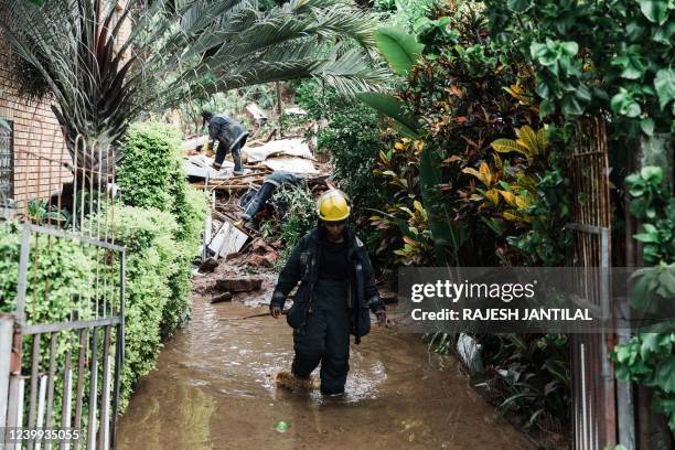 Members of the Ethekwini Metro Fire Department search for a person believed to be trapped after a mudslide at a house in Durban collapsed following...