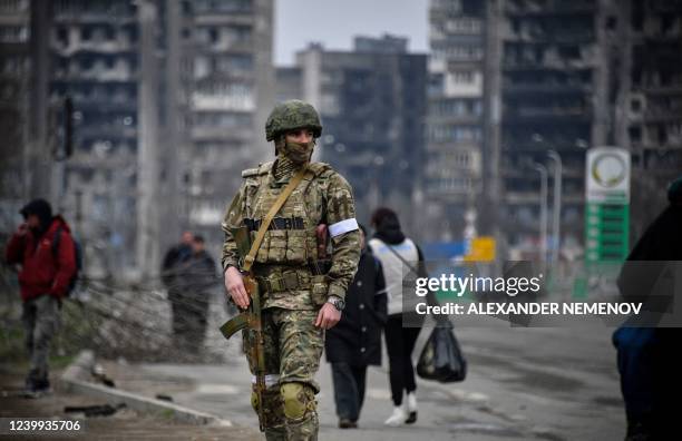 Russian soldier patrols in a street of Mariupol on April 12 as Russian troops intensify a campaign to take the strategic port city, part of an...