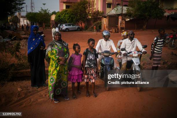 April 2022, Mali, Gao: Passers-by wait by the side of the road for the convoy of vehicles carrying the German Foreign Minister in Bamako, Mali. The...