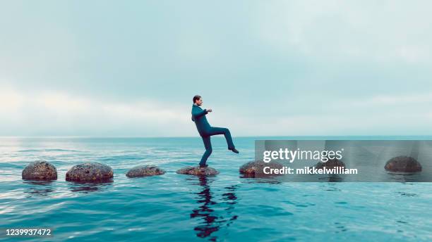 concept of stepping stones leading to right career path avoiding pitfalls - career path stock pictures, royalty-free photos & images