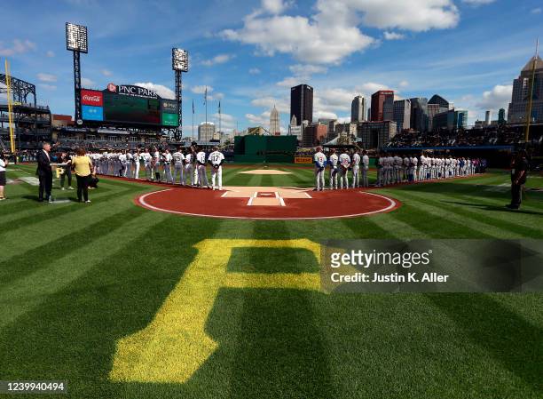 The Chicago Cubs and the Pittsburgh Pirates stand during the National Anthem during opening day at PNC Park on April 12, 2022 in Pittsburgh,...