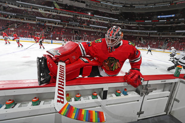 Goalie Collin Delia of the Chicago Blackhawks warms up with rainbow tape on his hockey stick in honor of Pride Night, prior to the game against the...