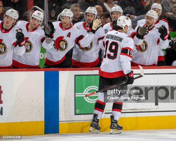 Drake Batherson of the Ottawa Senators pounds gloves with teammates after scoring a goal during the second period of an NHL game against the Detroit...