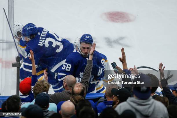 Toronto Maple Leafs left wing Michael Bunting battles for the puck along the boards while fans cheer as the Toronto Maples Leafs take on the Buffalo...