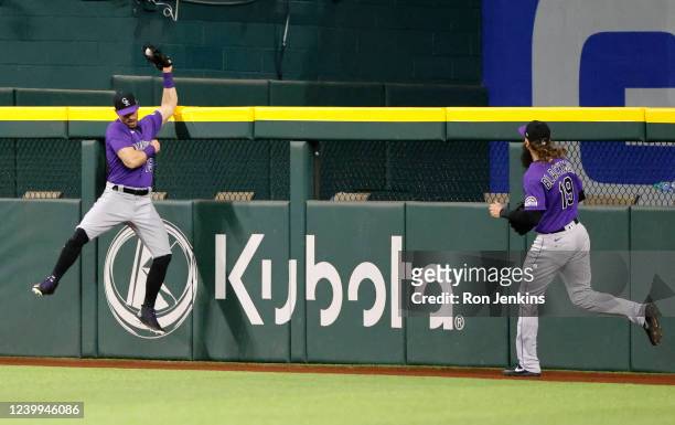 Randal Grichuk of the Colorado Rockies makes a leaping catch above the centerfield wall for a deep ball off the bat of Corey Seager of the Texas...