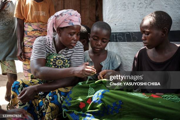 Lea Nyabenda , who has ten children and was displaced from her home since April 2020 due to the rise of the water level of Lake Tanganyika, teaches...