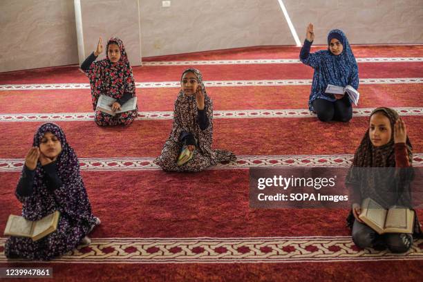 Palestinian girls read the Qur'an, the holiest book in Islam, during the holy month of Ramadan, in a mosque in Jabalia refugee camp in the northern...