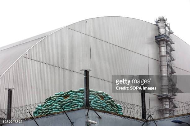 The New Safe Confinement structure at the Chernobyl power plant with a defensive position surrounded by sandbags. The New Safe Confinement structure...