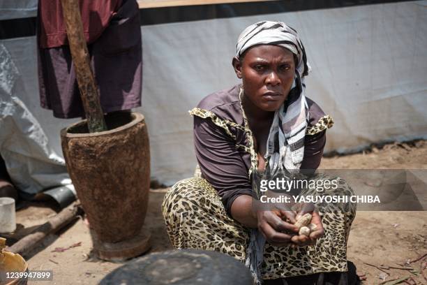 Amissa Irakoze , who has ten children and was displaced from her home since April 2020 due to the rise of the water level of Lake Tanganyika, poses...