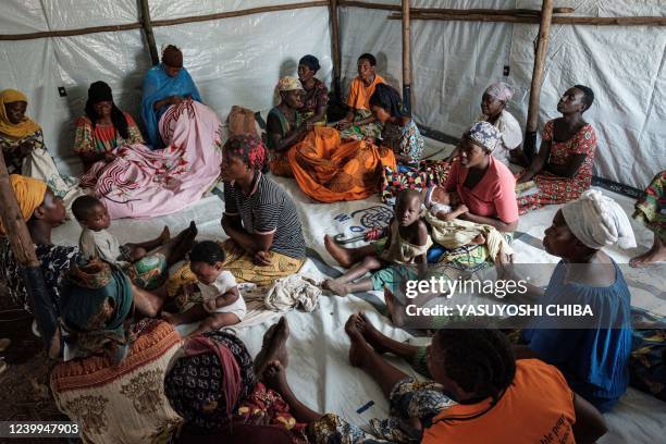 Mothers who have been displaced from their homes due to the rising water level of Lake Tanganyika listen to aid workers' advice in Kinyinya Two...