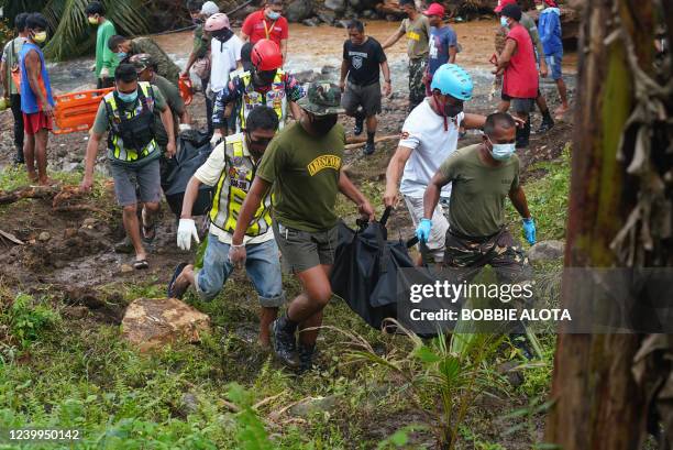 Rescue workers carry body bags containing the retrieved bodies of victims of a landslide that slammed the village of Bunga in Baybay town, Leyte...