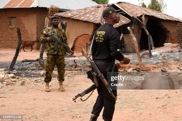 Security personnel stand guard in the Kukawa Village in the Kanam Local Government Area of the Plateau state on April 12, 2022 after resident's...