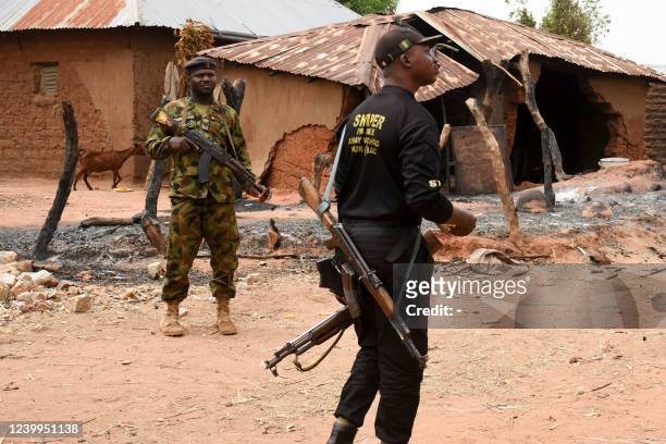Security personnel stand guard in the Kukawa Village in the Kanam Local Government Area of the Plateau state on April 12, 2022 after resident's...