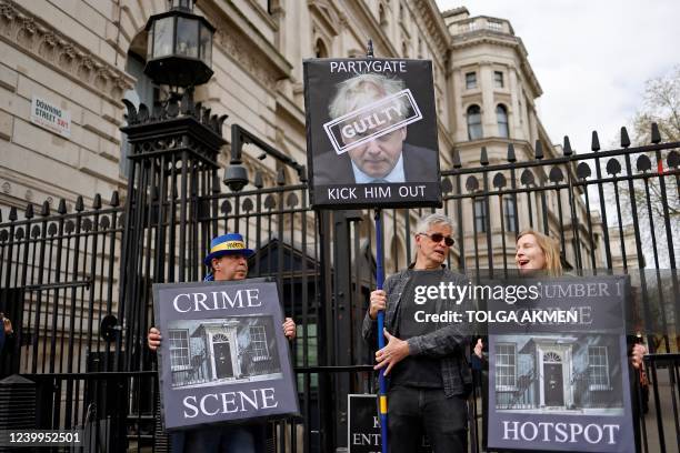 Demonstrators including anti-Brexit campaigner Steve Bray pose for a photograph holding placards as they protest outside the entrance to 10 Downing...