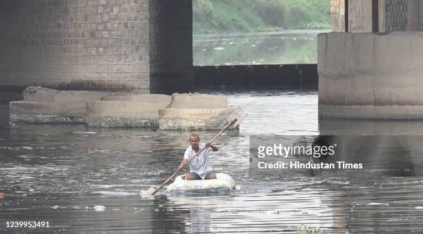 Man clean yamuna river at Chhath Ghat ITO, on April 12, 2022 in New Delhi, India.
