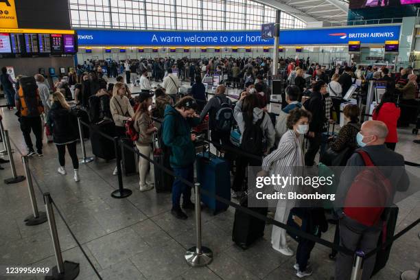 Passengers queue to check in at British Airways desks inside the departures hall of Terminal 5 at London Heathrow Airport in London, U.K., on...