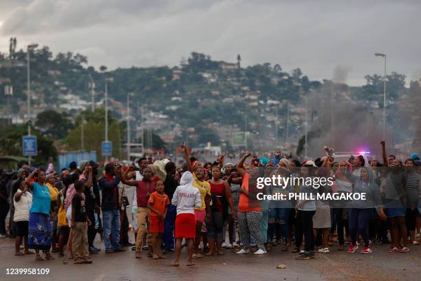 Residents of Bhambayi settlement raise their fists as they protest for water and electricity services while closing off the M25 highway in Inanda,...