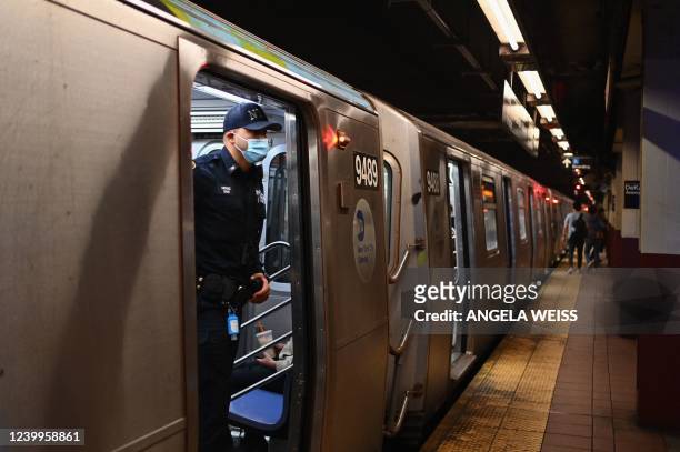 Officer looks out of a subway car in New York City on April 13 one day after people were injured during a rush-hour shooting in the Brooklyn borough...