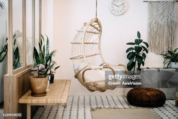 gemütlicher hängestuhl im loft-wohnzimmer mit stilvollem und bohemia-design. gut gestaltet und dekoriert mit einer auswahl an interessanten pflanzen - boho stock-fotos und bilder