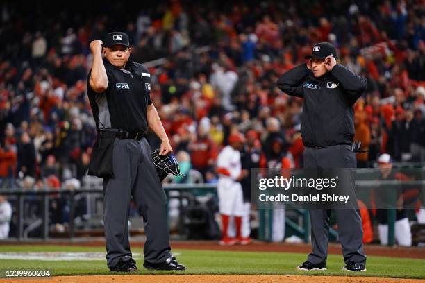 Umpire Mark Carlson and umpire Chris Guccione announce the results of a replay review to fans using the new wireless system during the game between...