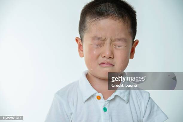 asian boy crying against white background - tear face stock pictures, royalty-free photos & images