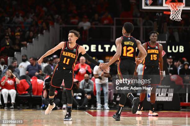 Trae Young and De'Andre Hunter of the Atlanta Hawks embrace during the 2022 Play-In Tournament on April 13, 2022 at State Farm Arena in Atlanta,...