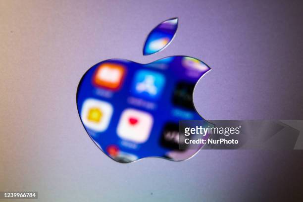 Icons displayed on iPhone screen are seen reflected in Apple logo on MacBook in this illustration photo taken in Krakow, Poland on April 13, 2022.