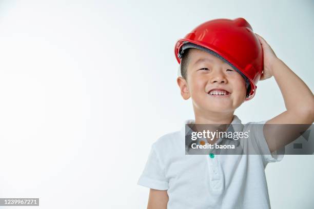 little boy engineer with protective helmet against white background - boy in hard hat stock pictures, royalty-free photos & images