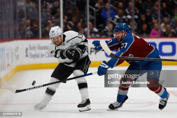 Viktor Arvidsson of the Los Angeles Kings shoots the puck into the offensive zone as J.T. Compher of the Colorado Avalanche defends during the first...