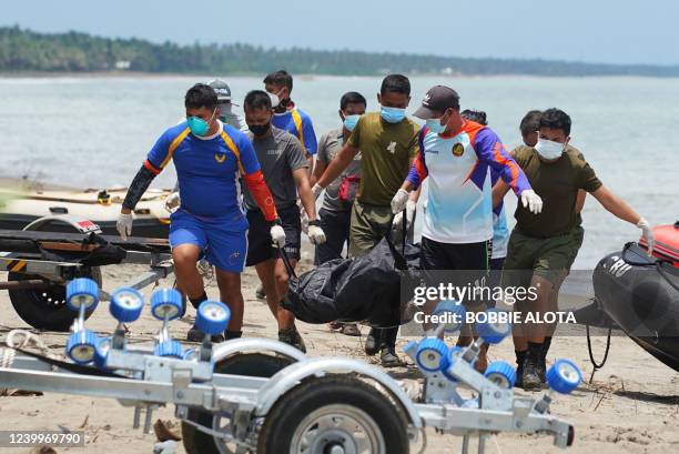Rescue workers carry a body bag containing a resident's dead body, victim of a landlside that slammed Pilar village in Abuyog town, Leyte province on...