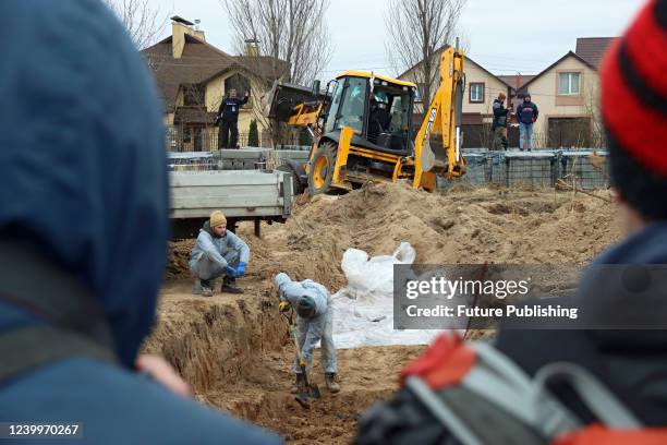The exhumation of dead bodies from another mass grave where civilians killed by Russian invaders are buried is underway in Bucha, Kyiv Region,...