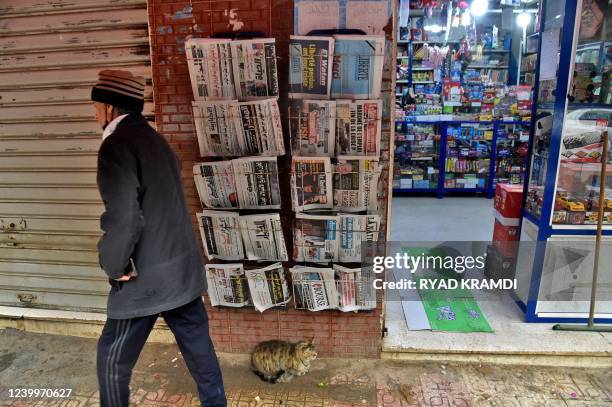 Man walks past a French-language daily newspaper stand displaying the final issue of Algerian French-language daily newspaper "Liberté" in Algeria's...