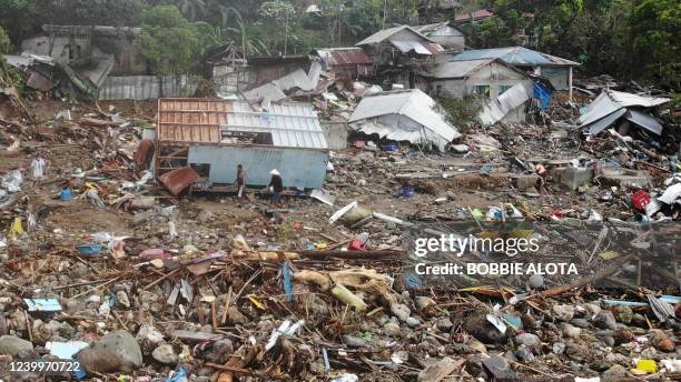 An aerial view shows residents walking past destroyed houses in the village of Pilar, Abuyog town, Leyte province on April 14, 2022 day after a...