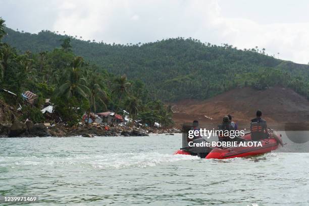 Rescue workers aboard an inflatable boat approach the village of Pilar, Abuyog town, Leyte province, on April 14, 2022 day after a landslide struck...