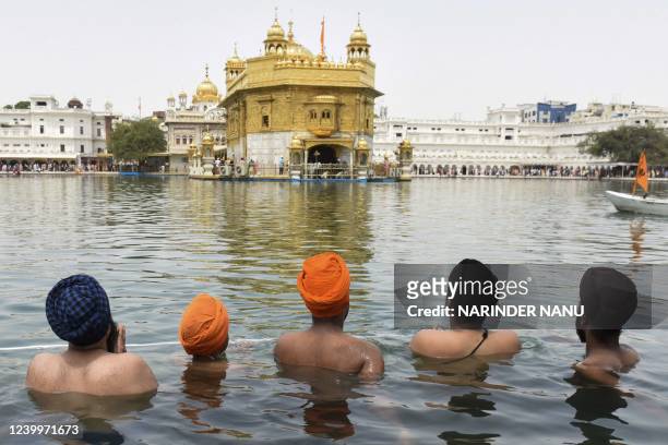 Sikh devotees take a bath in the sacred pond on the occasion of 'Baisakhi', a spring harvest festival for Sikhs and Hindus, at the Golden Temple in...