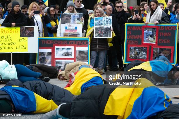 People lie on the ground, imitating the victims of the war in Ukrainian cities, in Toronto, Canada, on April 10, 2022. Mass graves of 350+ civilians...