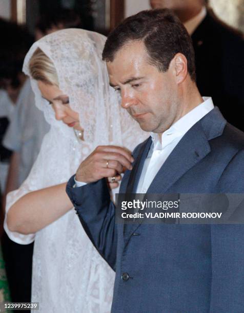 Russian President Dmitry Medvedev and his wife, Svetlana Medvedeva, cross themselves as they attend a service at the Holy Transfiguration Orthodox...