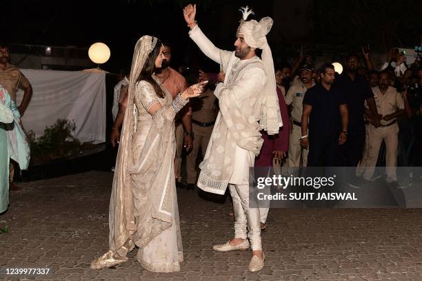 Bollywood actors Ranbir Kapoor and Alia Bhatt gesture during their wedding ceremony in Mumbai on April 14, 2022.