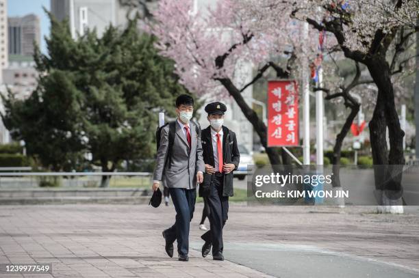 In this photo taken on April 13 students walk past cherry blossom trees near the Arch of Triumph in Pyongyang.