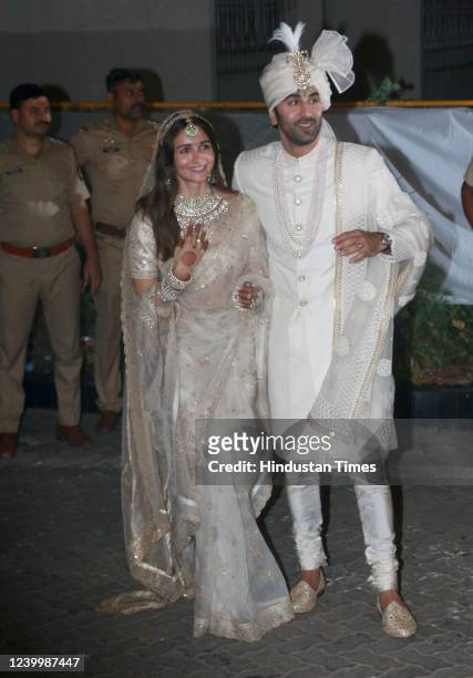 Bollywood actors Ranbir Kapoor and Alia Bhatt pose for photos after their wedding ceremony, outside their residence at Bandra on April 14, 2022 in...