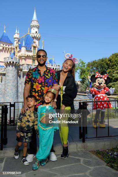 In this handout photo provided by Disneyland Resort, John Legend, Chrissy Teigen and their children, Miles and Luna pose with Minnie Mouse while...