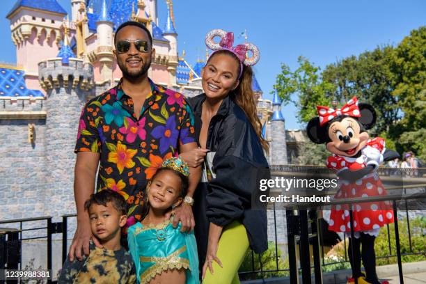 In this handout photo provided by Disneyland Resort, John Legend, Chrissy Teigen and their children, Miles and Luna pose with Minnie Mouse while...