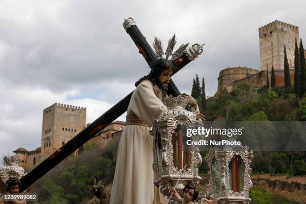 The image of Padre Jesus del Amor with a view of the Alhambra monument during the Maundy Thursday in Granada, Spain, on April 14, 2022. Holy Week...