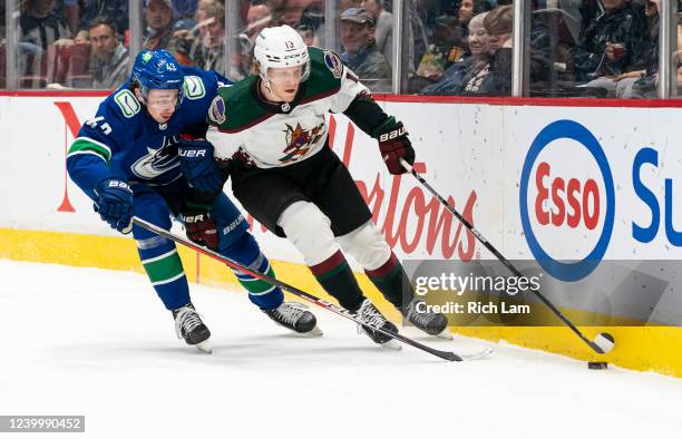 Nathan Smith of the Phoenix Coyotes skates the puck against Quinn Hughes of the Vancouver Canucks during the first period at Rogers Arena on April...